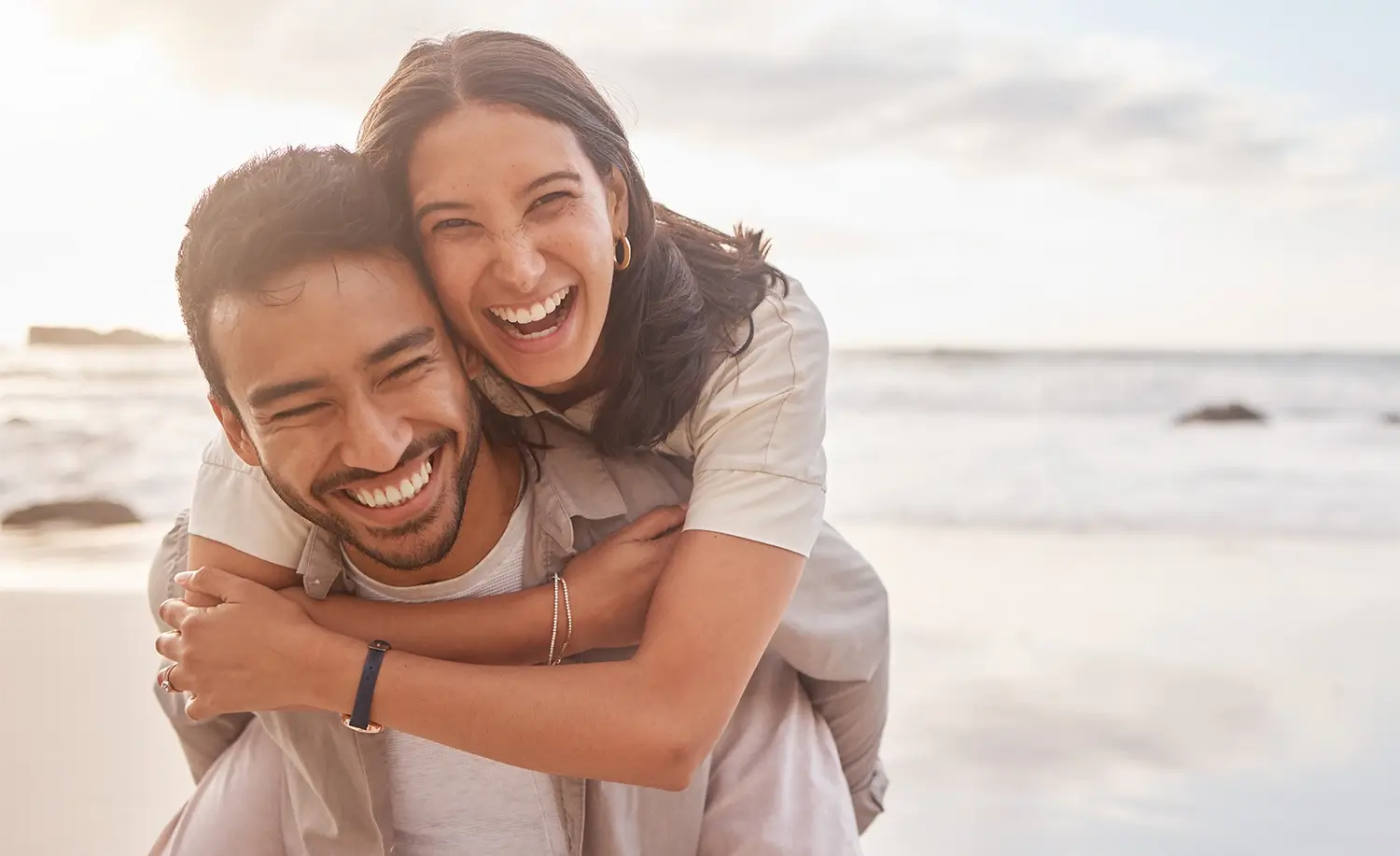 junges, lachendes Paar am Strand