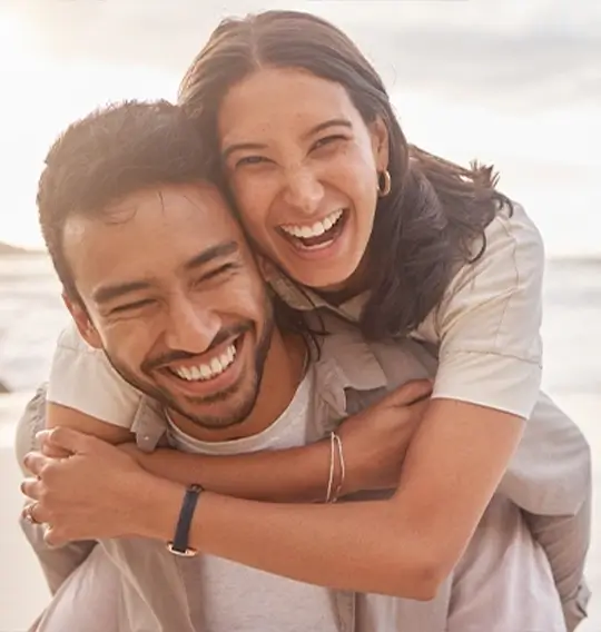 junges, lachendes Paar am Strand