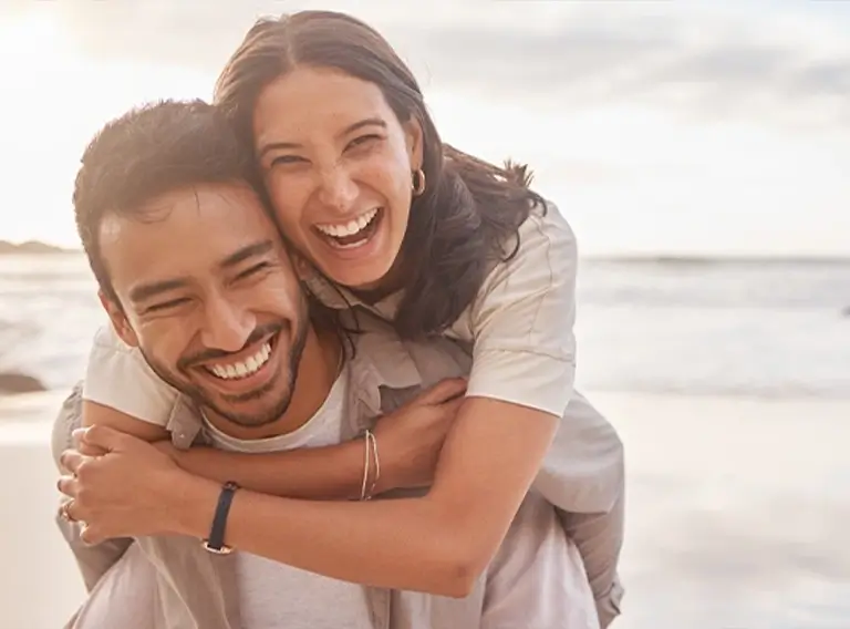 junges, lachendes Paar am Strand